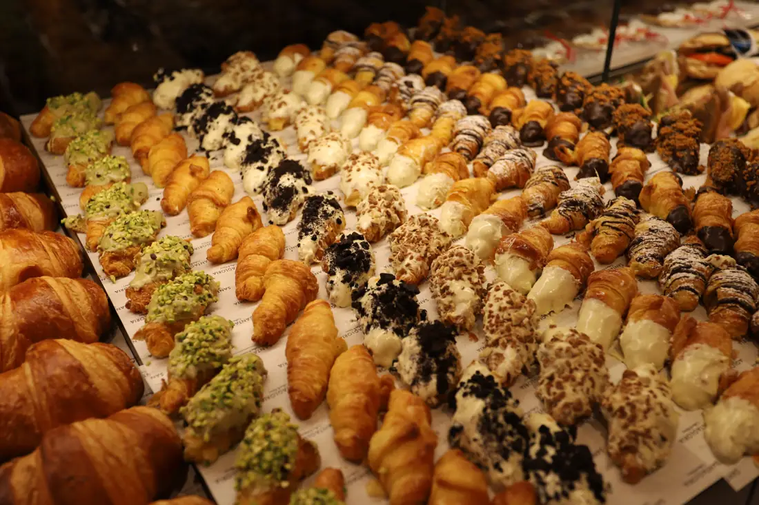 Charolas de croissants y mini bollería recién horneados